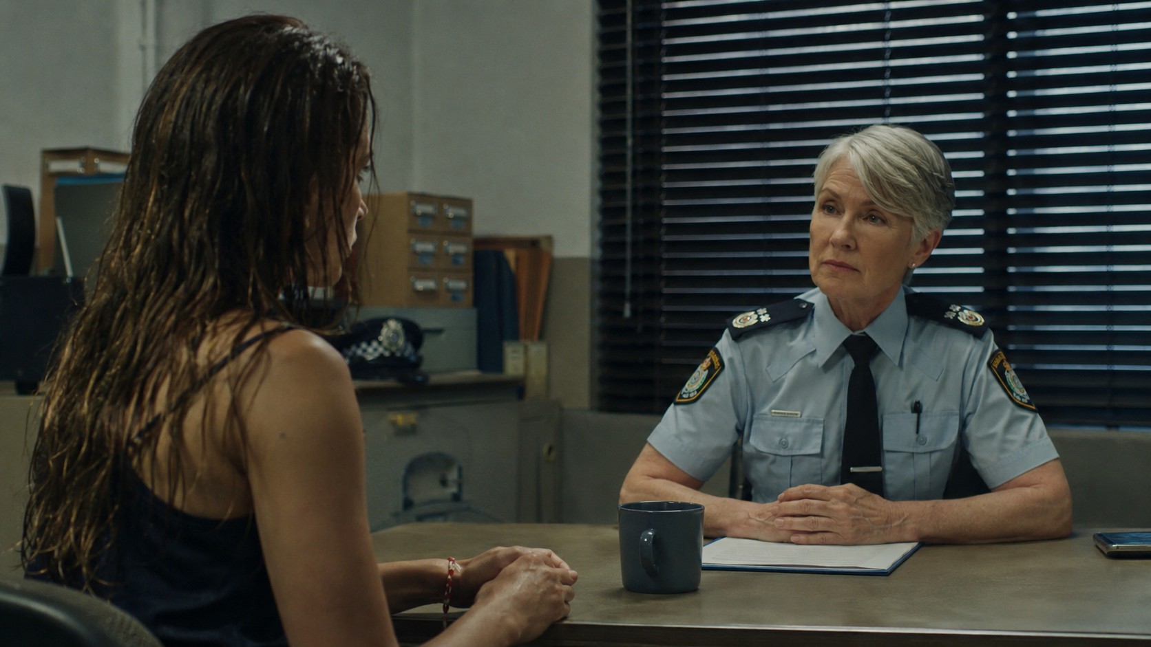 Ru sitting across from a police officer, concept image for the LOST feature
